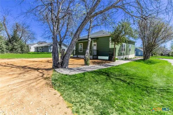 a view of a house with garden and trees