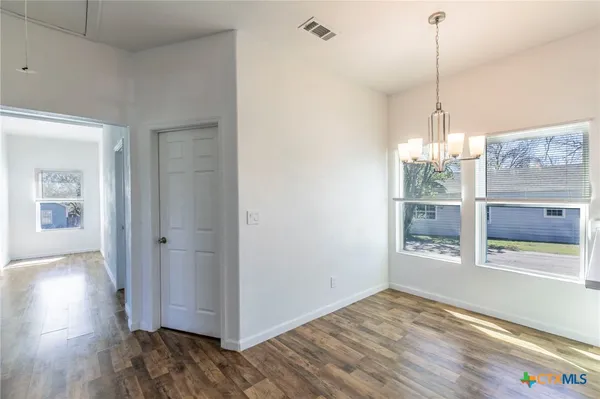 a view of a room with wooden floor and windows