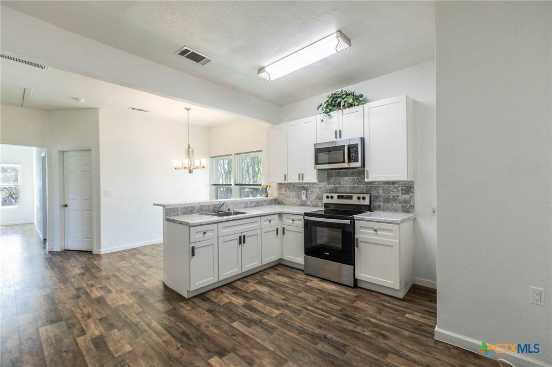 914 South 2nd Street Temple, TX 76504 - Photo 8 of 25 a kitchen with granite countertop a stove top oven microwave and refrigerator