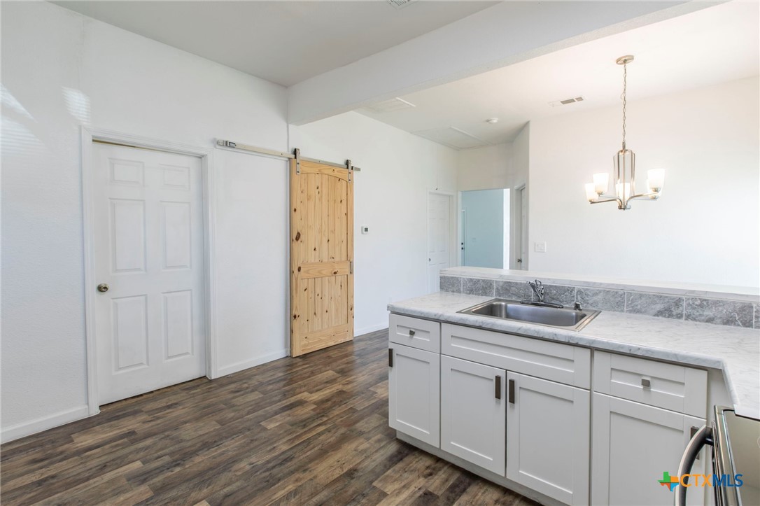 914 South 2nd Street Temple, TX 76504 - Photo 9 of 25 a spacious bathroom with a granite countertop sink a mirror and a shower