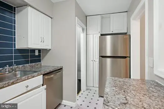 a kitchen with granite countertop a refrigerator and a sink