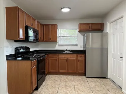 a kitchen with stainless steel appliances granite countertop a refrigerator a stove a sink and a microwave