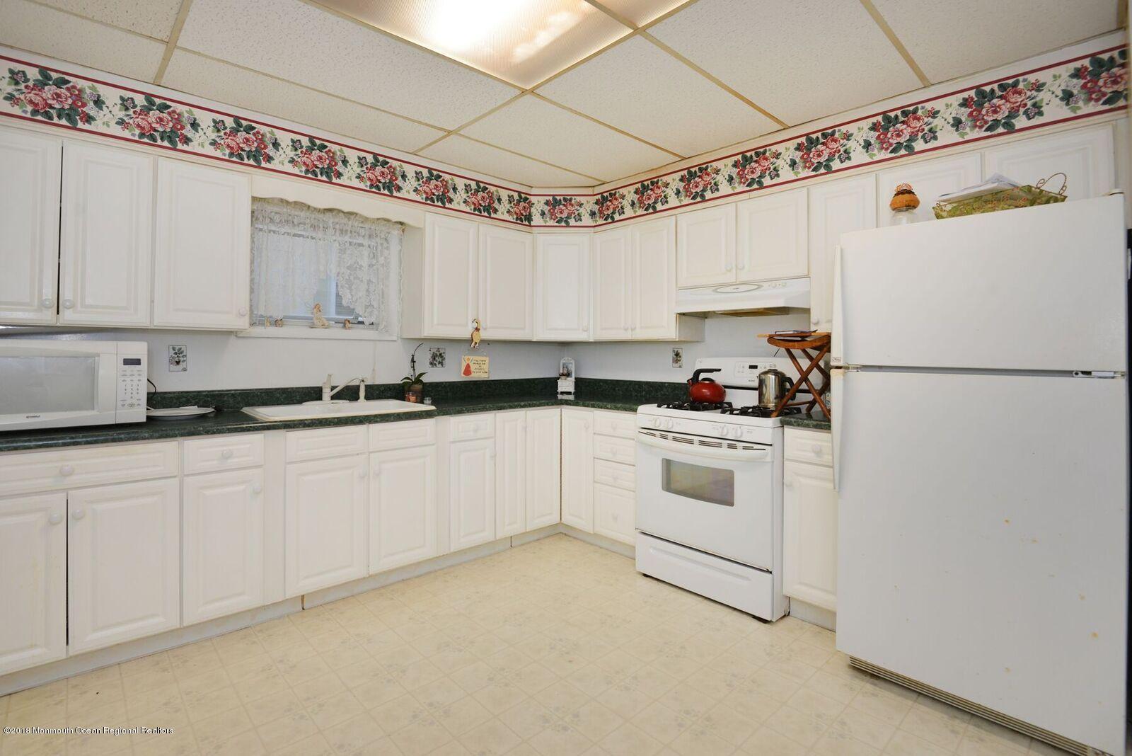 77 Cookman Avenue Ocean Grove, NJ 07756 - Photo 14 of 23 a kitchen with granite countertop white cabinets and white appliances