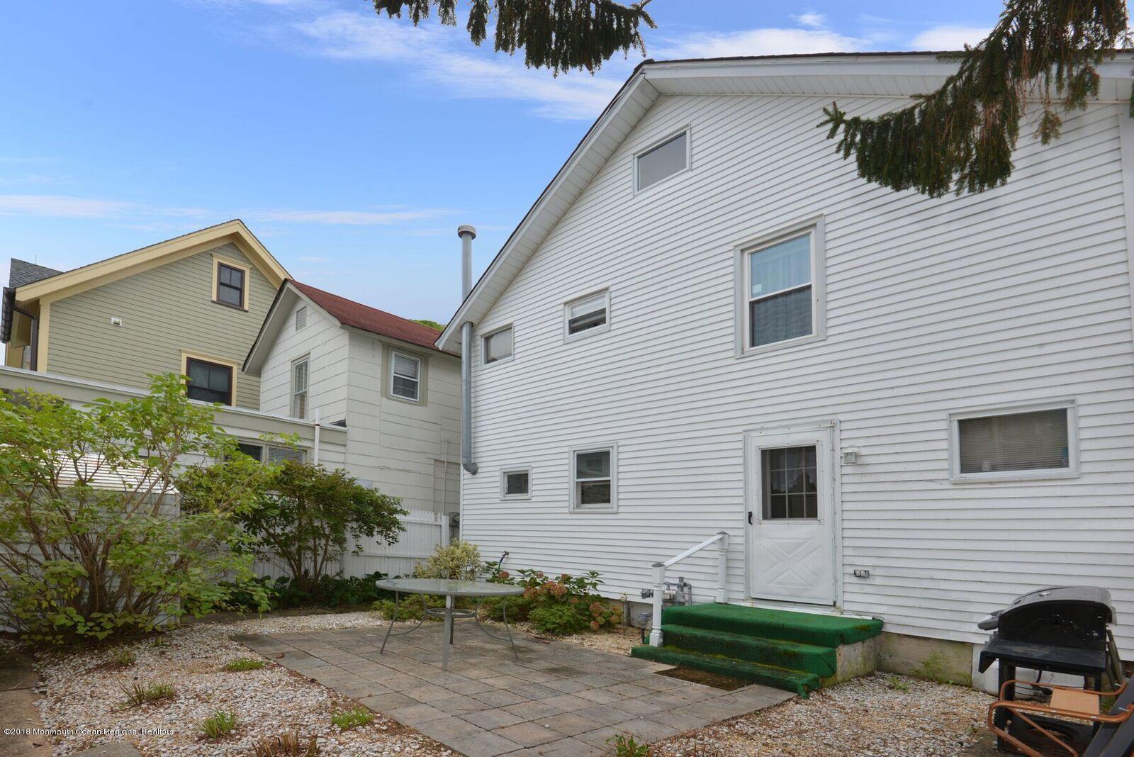 77 Cookman Avenue Ocean Grove, NJ 07756 - Photo 21 of 23 a view of a white house with a small yard and a large window