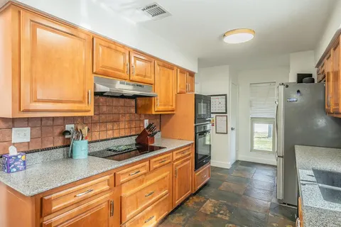 a kitchen with stainless steel appliances granite countertop a refrigerator and a sink