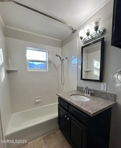 a bathroom with a granite countertop sink a toilet a mirror and bathtub