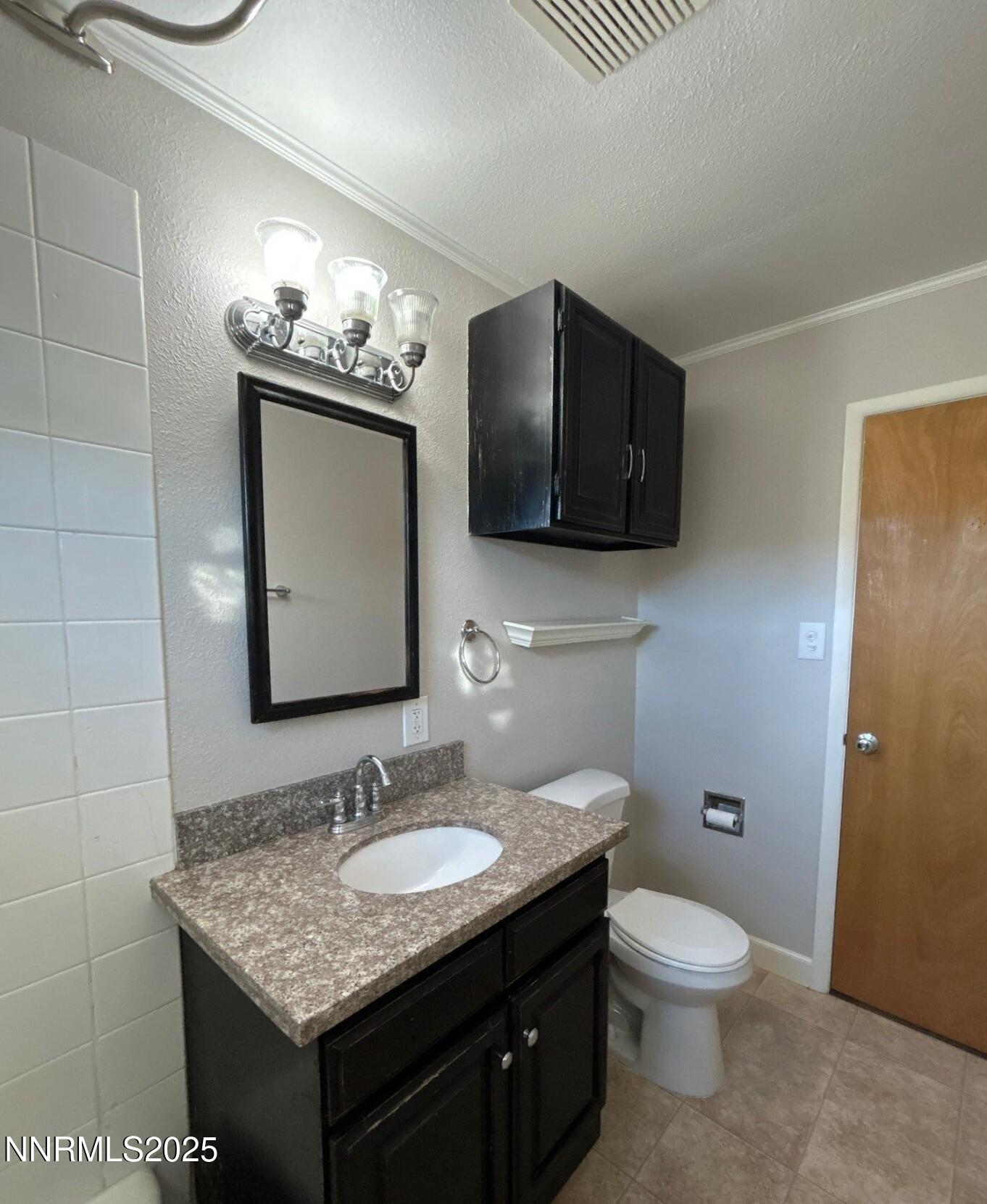 660 Kirman Avenue Reno, NV 89502 - Photo 13 of 17 a bathroom with a granite countertop sink a toilet and mirror