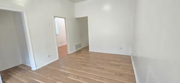a view of an empty room with wooden floor