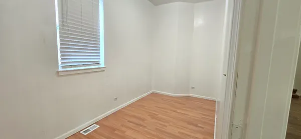 a view of a room with wooden floor and a window