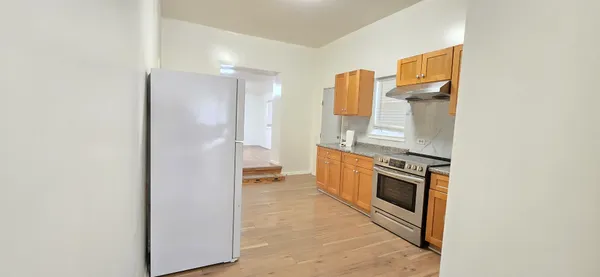 a kitchen with stainless steel appliances granite countertop a refrigerator and a stove