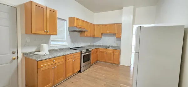 a kitchen with stainless steel appliances granite countertop a sink and a refrigerator