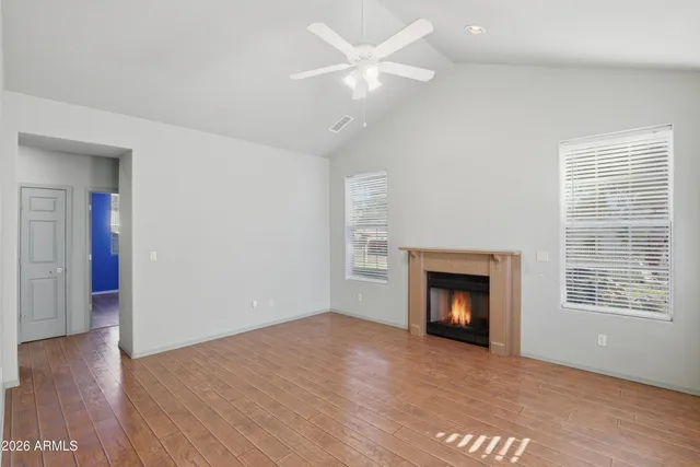 an empty room with a fireplace and wooden floor