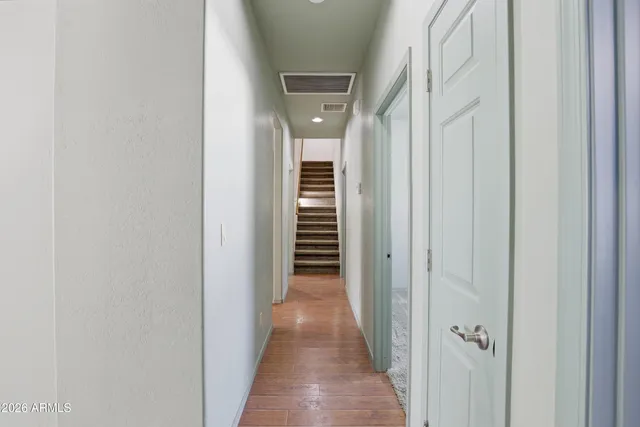 a view of a hallway with wooden floor and stairs