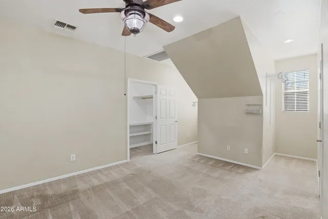 an empty room with closet and windows