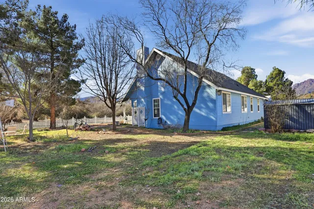 a view of a yard in front of a house with large trees