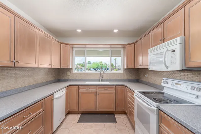 a kitchen with a sink window and cabinets