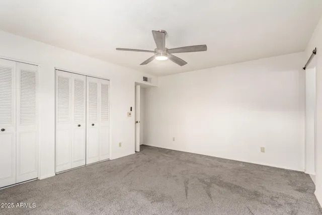 an empty room with chandelier fan