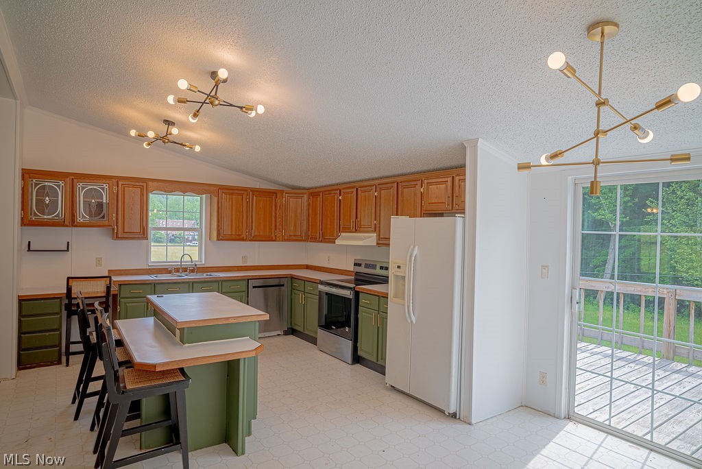 967 Buck Run Road Mineral Wells, WV 26150 - Photo 23 of 50 Kitchen featuring wood-finish upper cabinetry, green lower cabinetry, a center island with countertop seating, stainless steel appliances, and two contemporary ceiling light fixtures