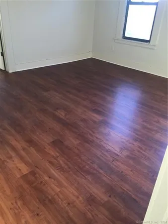 a view of a room with wooden floor and window