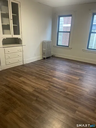 an empty room with wooden floor and window