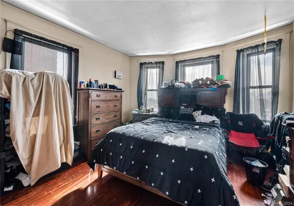 a bedroom with a bed dresser and a window