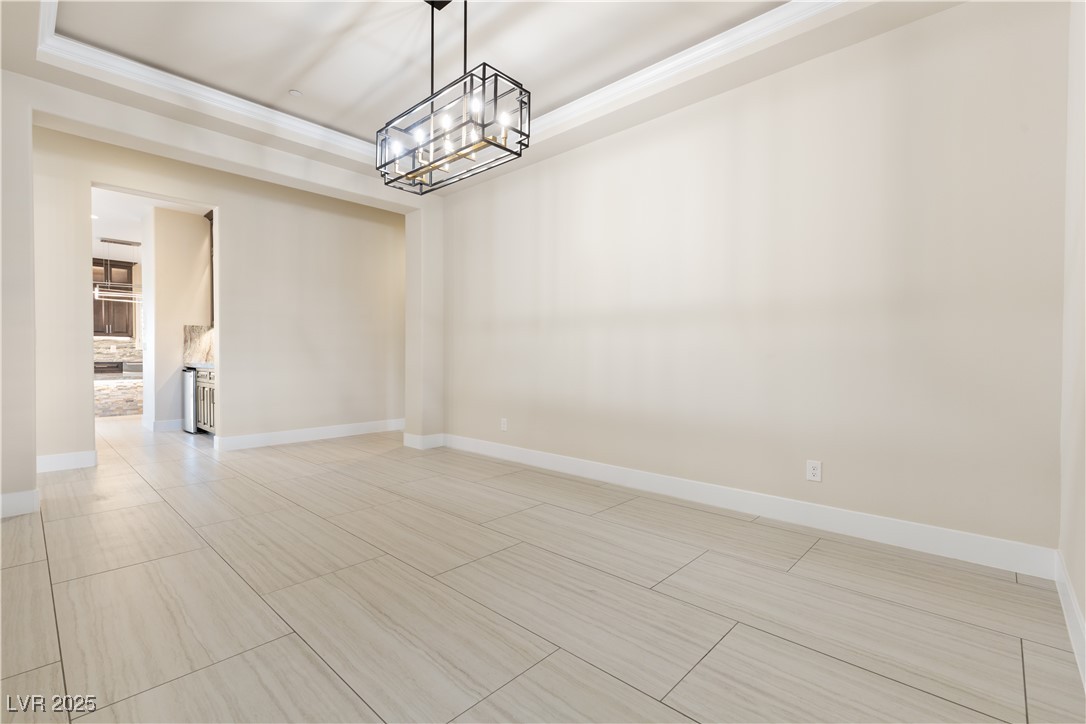 9865 Bright Angel Way Las Vegas, NV 89149 - Photo 43 of 98 Dining room featuring a chandelier, a tray ceiling, and baseboards