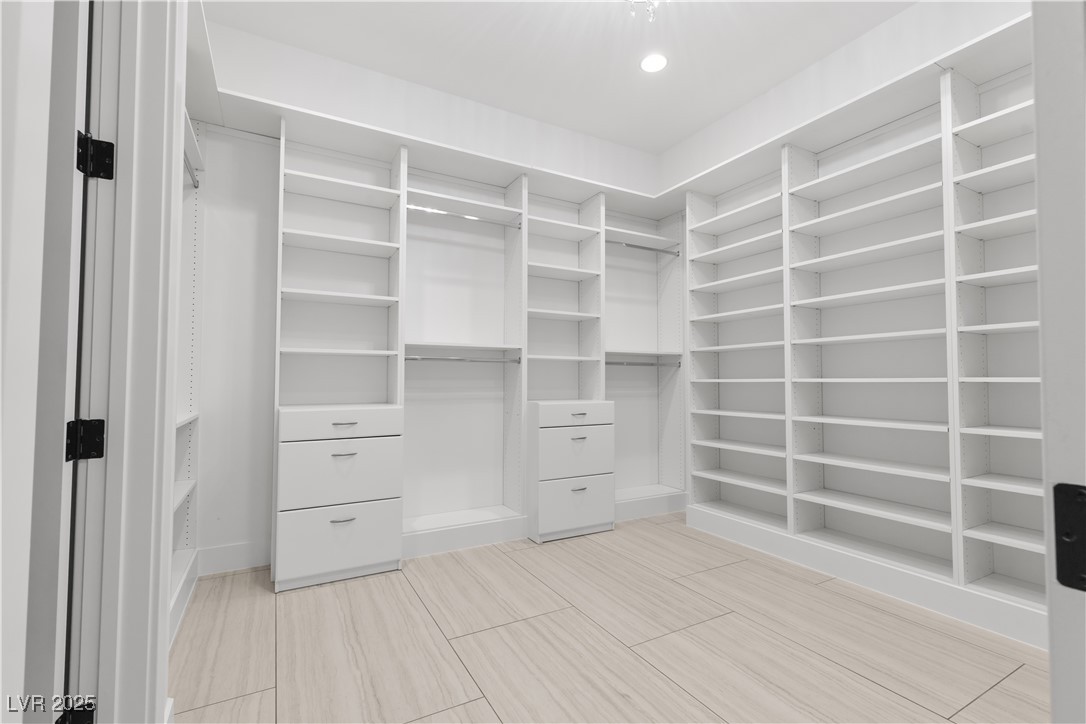 9865 Bright Angel Way Las Vegas, NV 89149 - Photo 54 of 98 Primary Walk In Closet #1, Adjustable Melamine Shelving, Drawer Banks, featuring a chandelier.