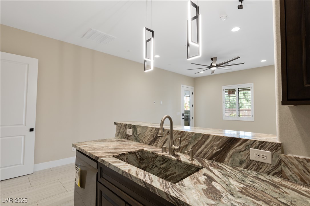 9865 Bright Angel Way Las Vegas, NV 89149 - Photo 68 of 98 Casita 1 Kitchen featuring a sink, stainless steel dishwasher, light stone countertops, ceiling fan, and dark brown cabinets