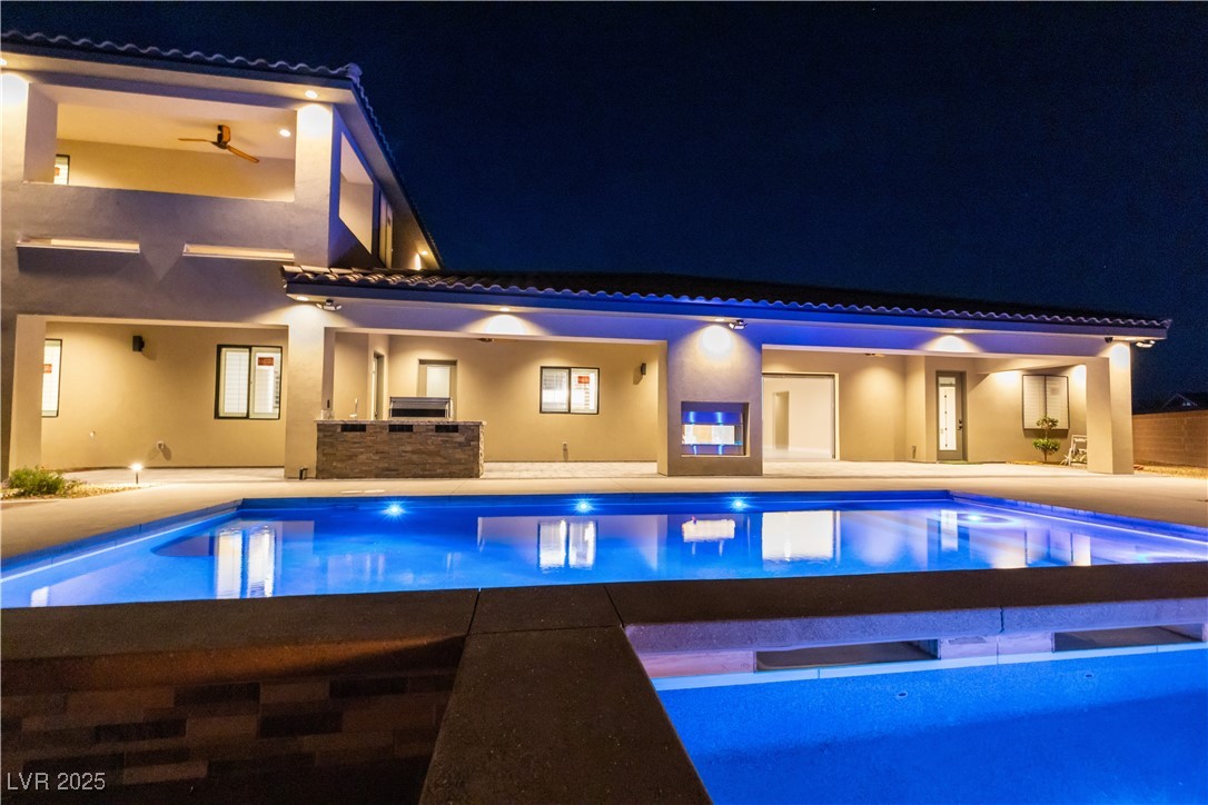 9865 Bright Angel Way Las Vegas, NV 89149 - Photo 10 of 98 Pool at night featuring an outdoor pool, a patio area, and an outdoor kitchen