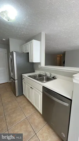 a kitchen with stainless steel appliances a sink stove and refrigerator