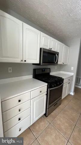 a kitchen with granite countertop a stove and a microwave