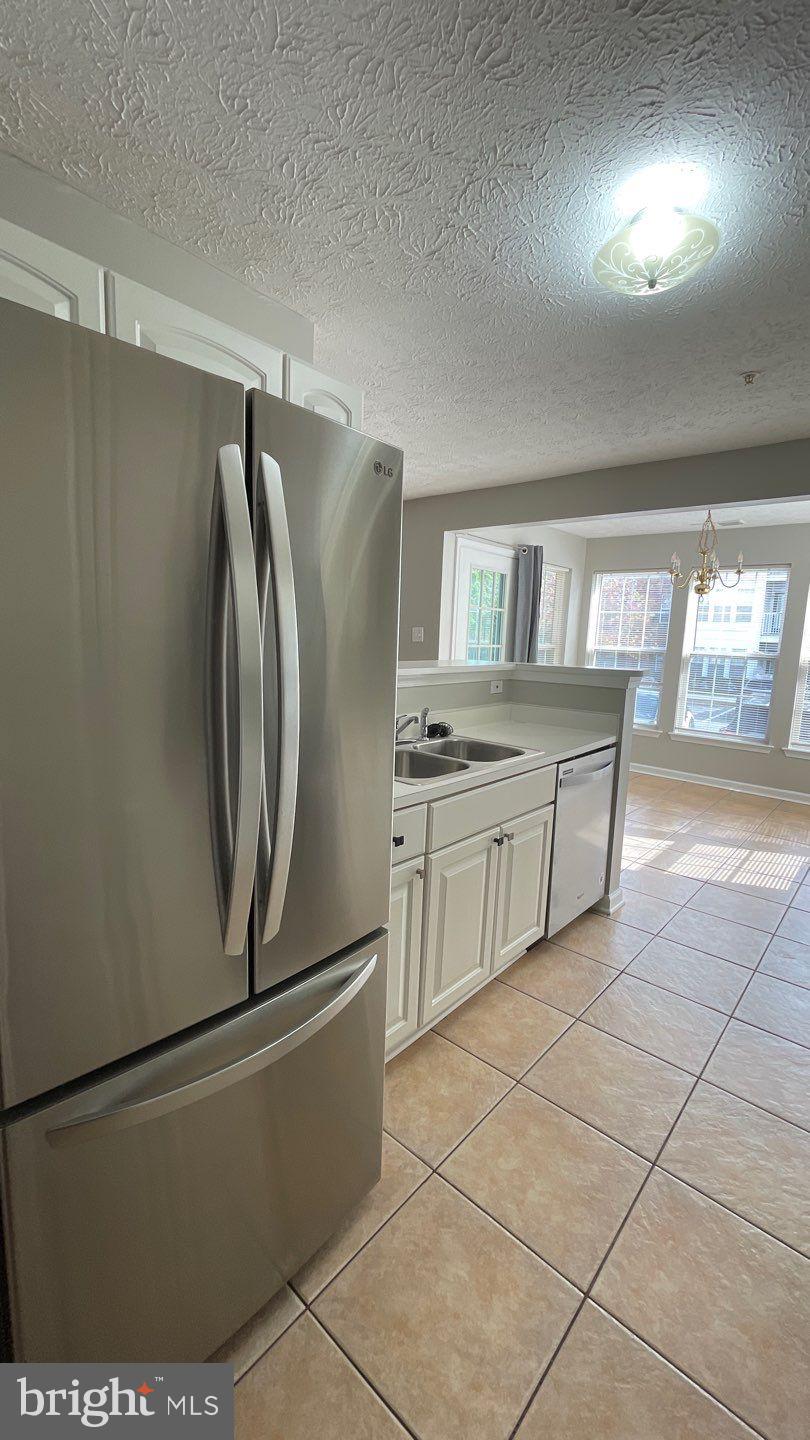 4915 Riders Court, Unit 4915 Owings Mills, MD 21117 - Photo 14 of 25 a kitchen with stainless steel appliances a refrigerator sink and cabinets