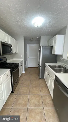 a large kitchen with cabinets and steel stainless steel appliances
