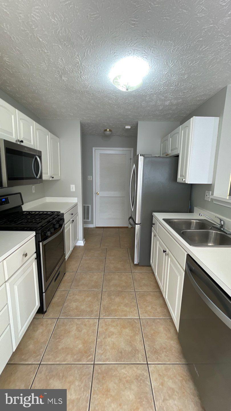 4915 Riders Court, Unit 4915 Owings Mills, MD 21117 - Photo 10 of 25 a large kitchen with cabinets and steel stainless steel appliances