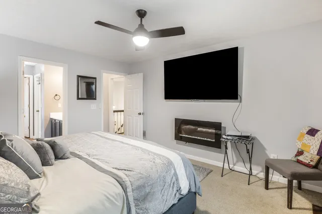 a bedroom with a bed a flat screen tv and a couch