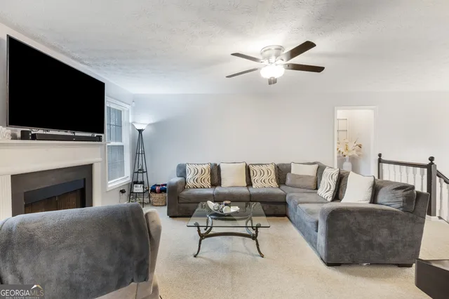 a living room with furniture a fireplace and a flat screen tv