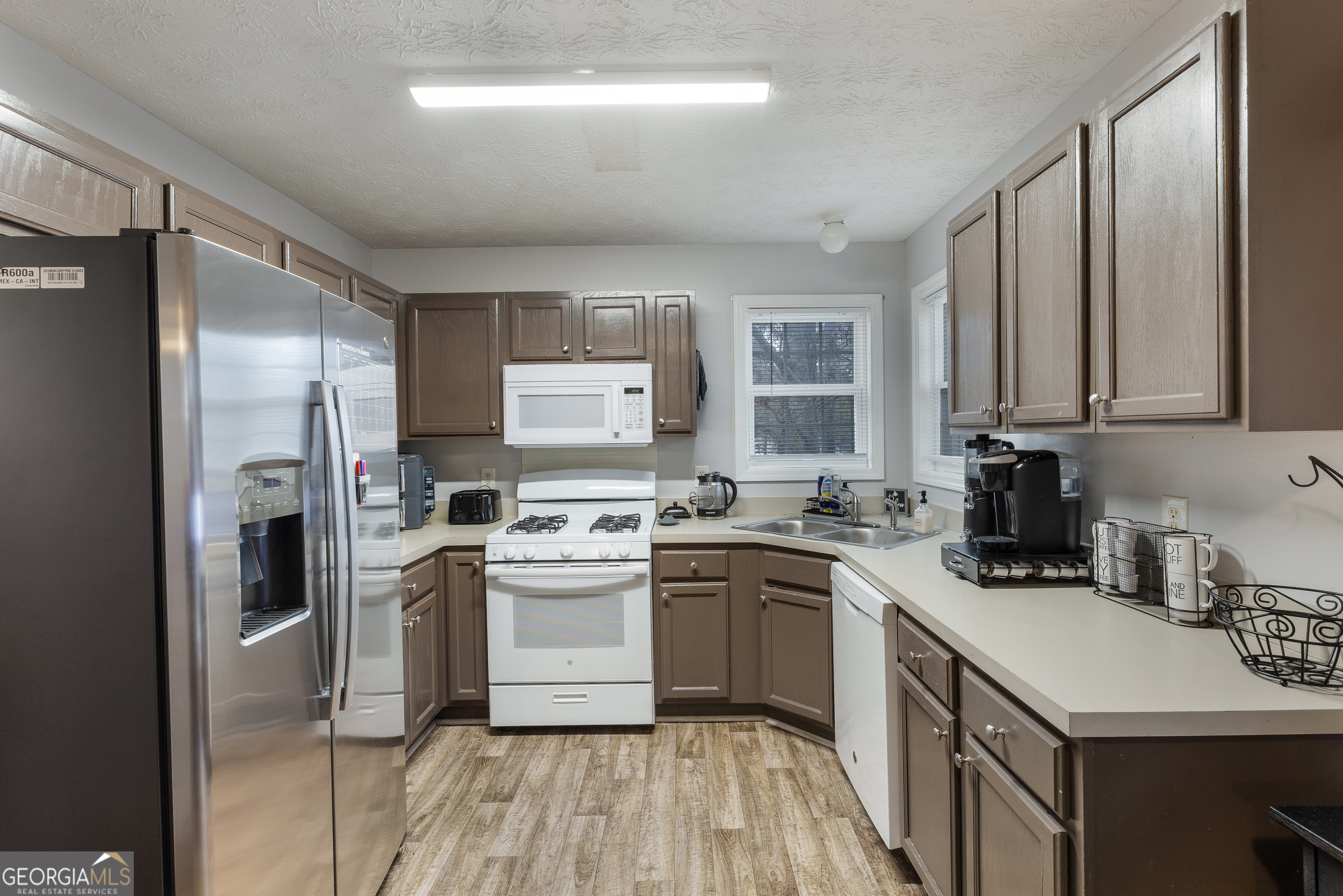 159 Villa Rosa Ridge Temple, GA 30179 - Photo 7 of 31 a kitchen with a sink a refrigerator and cabinets