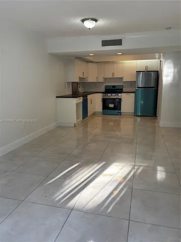 a view of kitchen with refrigerator and stove