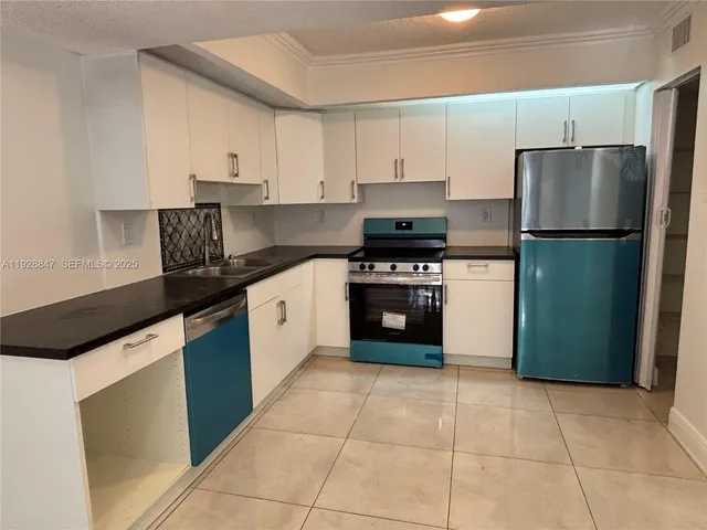 a kitchen with a stove a refrigerator and a sink