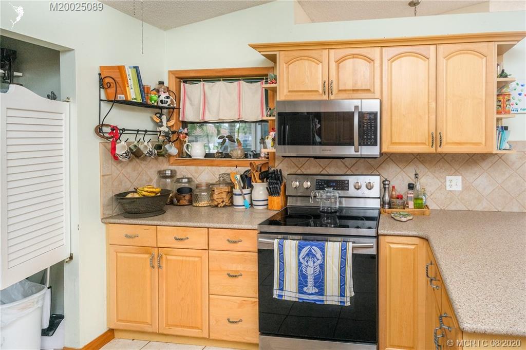 4063 Southeast Jacaranda Street Stuart, FL 34997 - Photo 12 of 34 a kitchen with granite countertop a stove a sink and a microwave