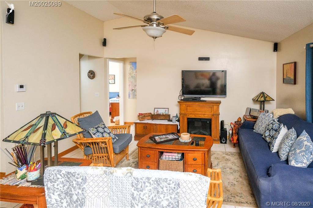 4063 Southeast Jacaranda Street Stuart, FL 34997 - Photo 14 of 34 a living room with furniture a fireplace and a flat screen tv