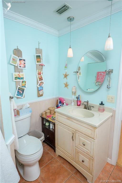 4063 Southeast Jacaranda Street Stuart, FL 34997 - Photo 18 of 34 a bathroom with a sink vanity mirror and toilet