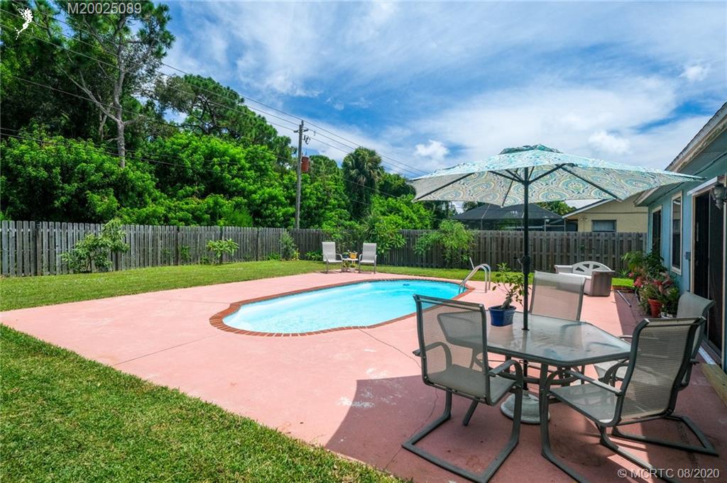 4063 Southeast Jacaranda Street Stuart, FL 34997 - Photo 2 of 34 a view of a backyard with swimming pool and furniture