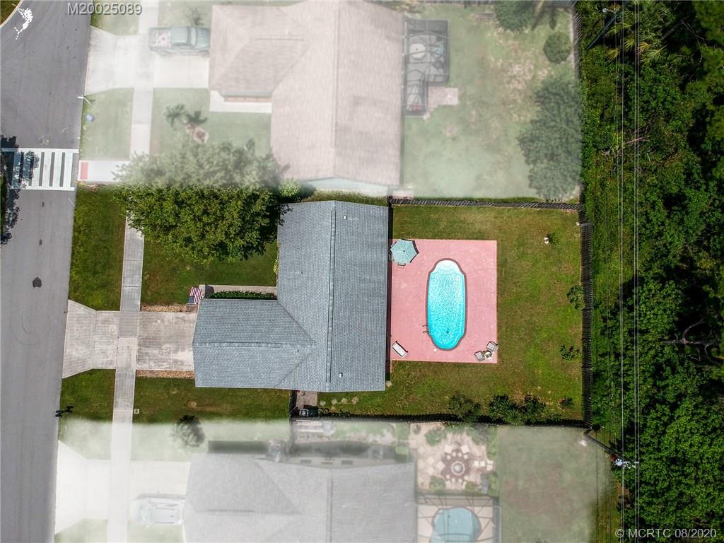 4063 Southeast Jacaranda Street Stuart, FL 34997 - Photo 26 of 34 a view of a brick building with a yard