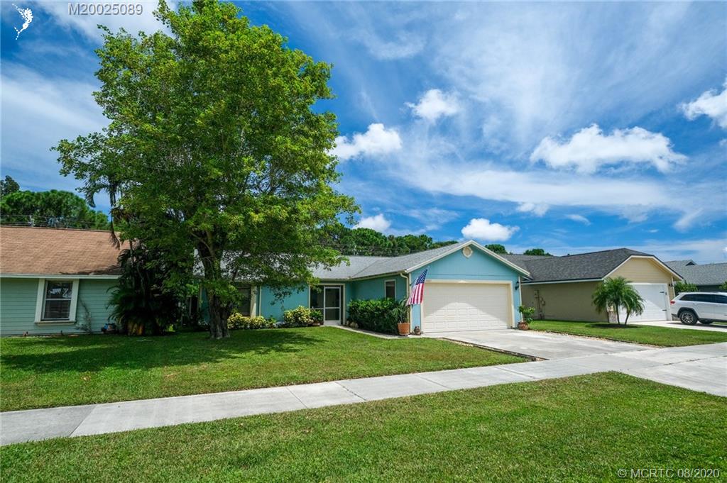 4063 Southeast Jacaranda Street Stuart, FL 34997 - Photo 29 of 34 a view of a house with a big yard plants and large trees