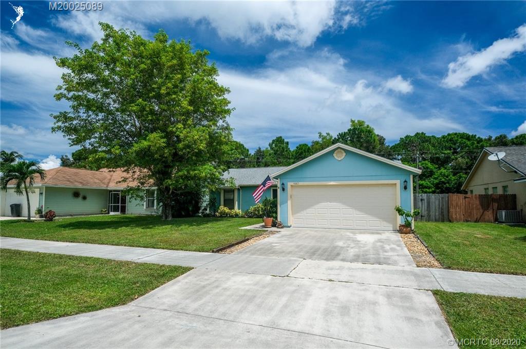 4063 Southeast Jacaranda Street Stuart, FL 34997 - Photo 30 of 34 a front view of a house with a yard
