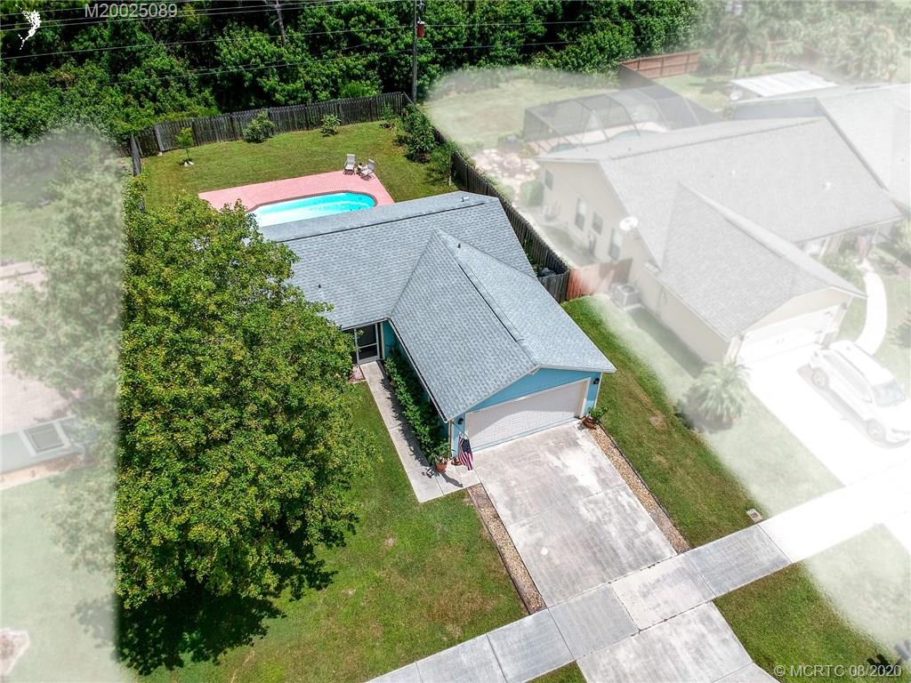 4063 Southeast Jacaranda Street Stuart, FL 34997 - Photo 3 of 34 an aerial view of a house with a yard and large trees