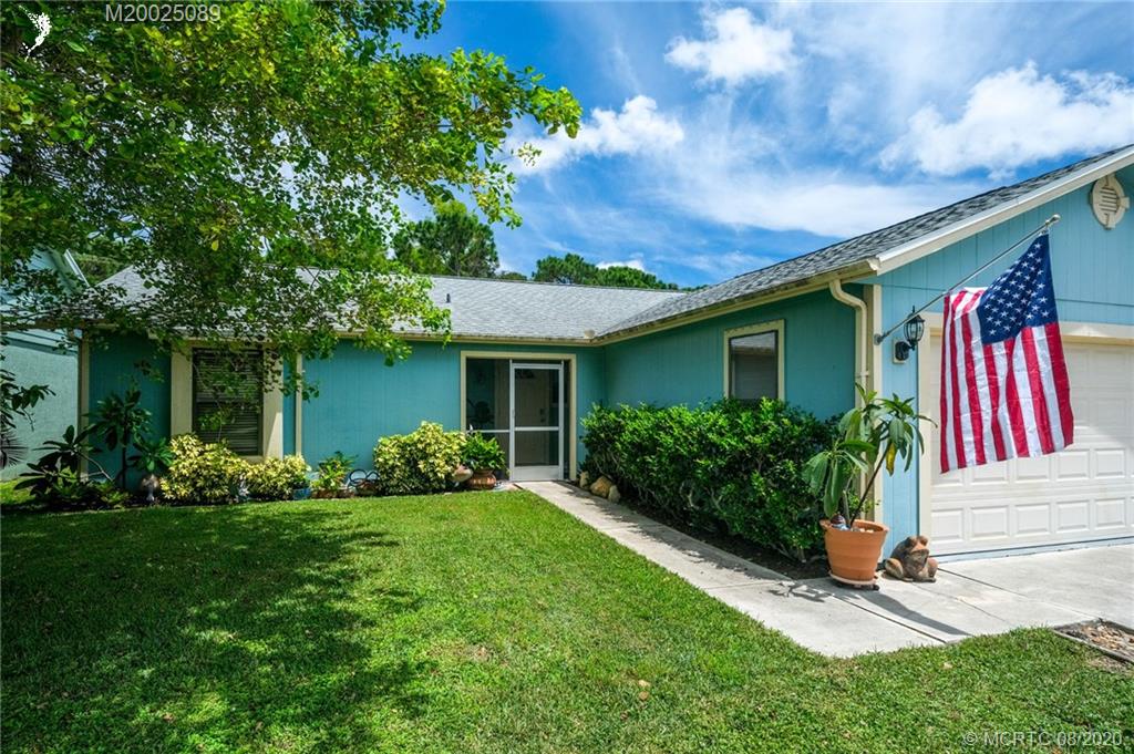4063 Southeast Jacaranda Street Stuart, FL 34997 - Photo 32 of 34 a front view of a house with garden