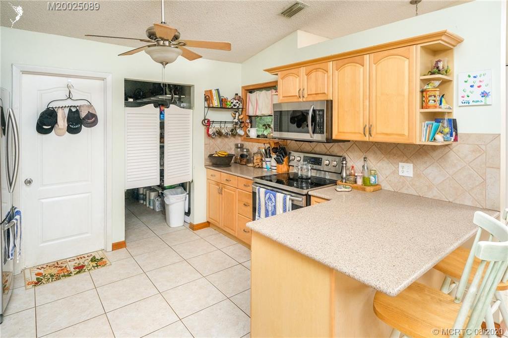 4063 Southeast Jacaranda Street Stuart, FL 34997 - Photo 5 of 34 a kitchen with stainless steel appliances a refrigerator and microwave