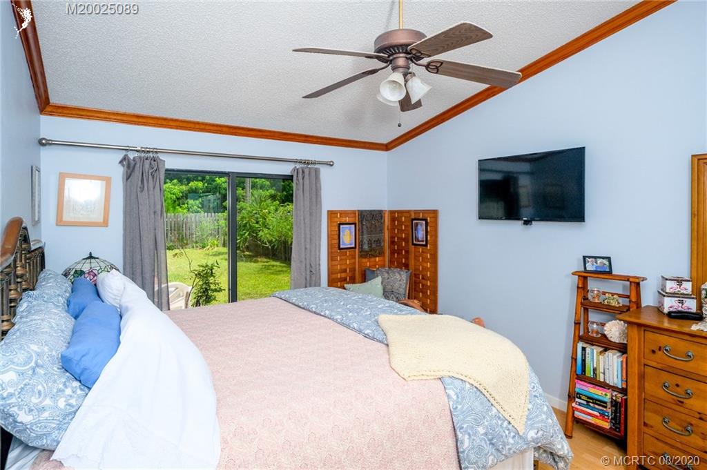 4063 Southeast Jacaranda Street Stuart, FL 34997 - Photo 8 of 34 a bedroom with a bed a flat screen tv and a window